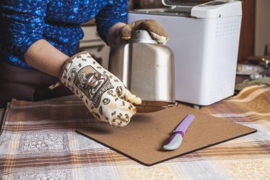Kadının fırın eldiveni çekme taze ekmek ekmek elektrikli ekmek makinesi pişirme için kalıp üzerinden eller