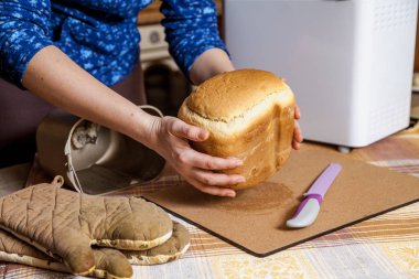 kadının ellerini--dan kalıp elektrikli ekmek Maker fırın ekmek taze ekmek tutun. Yakın büyük bir bıçak