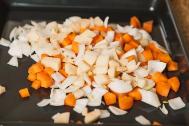 Sebze Güveç hazır olun. Dilimlenmiş havuç, patates ve beyaz lahana yalan bir siyah metal pişirme üzerinde