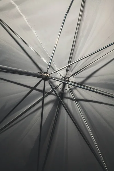 Umbrella construction. Opened white umbrella view from the inside. Metal spokes are visibl