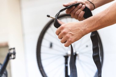 Motosikletin kamerasını değiştiriyorum. Bisikletçinin elleri metal uçlu kauçuk bir hazne tutuyor.