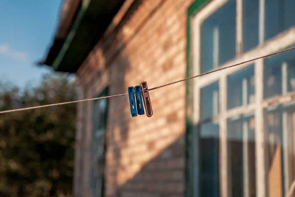 Három Műanyag Clothespins Mérjünk Egy Vékony Kötélen Háttérben Egy Tégla — Stock Fotó