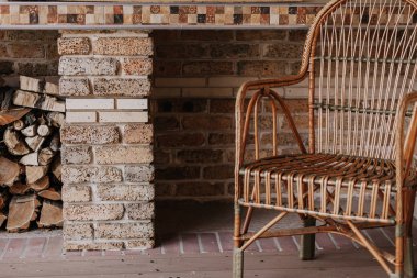 Güzel hasır sandalye rattan gelen boş bir verandada arkadan standları sonbahar hikaye ışık delinmiş yakacak odun yığınını yatıyor