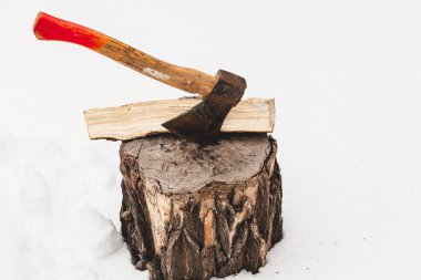 Yakacak odun kışın Gaze. Baltayı saçılmış bir oturum açma beyaz açık sno güdük ortaya sopalarla