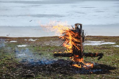 Slav tatil kış sonu. Donmuş nehir kıyısında, gözleme saman bir büst kalıntıları wee