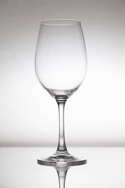 Boş şeffaf cam şarap cam cam portre üzerinde duruyor. Aşağıda görünür yansımasıdır