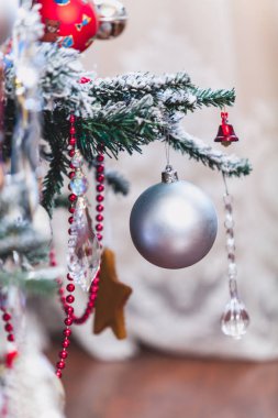 Bir Noel ağacı yeşil bir dalda asılı şirin yılbaşı oyuncak beyaz mat top. Kırmızı garlan