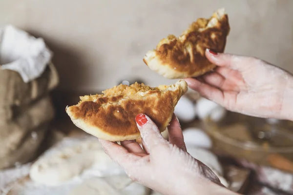 stock image Women hands holding the two halves of a large fried patt