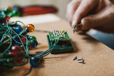 Yeni yıl için hazırlanıyor. Köknar ağacı elektrik çelenk tamiri. El ile küçük bir scre holding cımbız