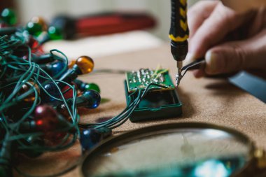 Yeni yıl için hazırlanıyor. Köknar ağacı elektrik çelenk tamiri. El ile küçük bir scre holding cımbız