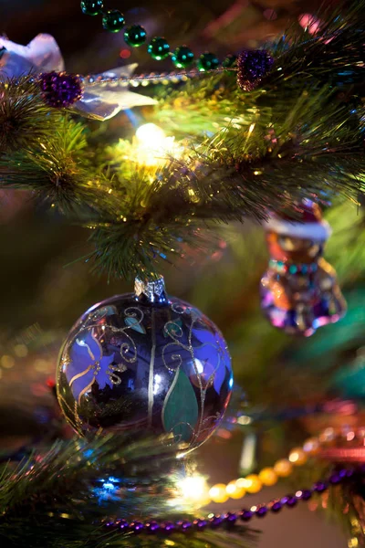碗与花图案挂在圣诞树上的绿色冷杉分枝特写镜头 在模糊的灯光和花环周围 — 图库照片