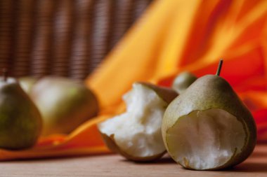 Armut ile natürmort. Isırık izleri görünür olan iki yeşil armut turuncu kumaş bir arka plan üzerinde yalan. Tüm sa