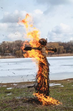 Slav tatil kış sonu. Saman büyük bir Shrovetide bebek nehir kıyısında yakar. Siyah duman görünür