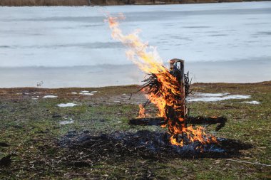 Slav tatil kış sonu. Donmuş nehir kıyısında, gözleme saman bir büst kalıntıları wee