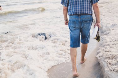 Şort yaz akşam deniz kumsalda yürüyen adam