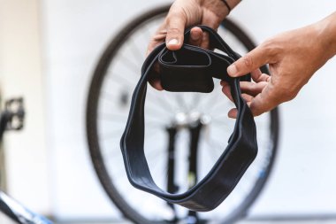 Motosikletin kamerasını değiştiriyorum. Bisikletçinin elleri metal uçlu kauçuk bir hazne tutuyor.