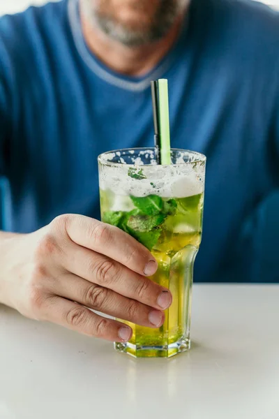 Mans Hand Holds Tall Transparent Glass Mojito Cocktail Straw Tabl — Stock Photo, Image