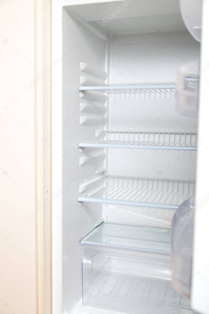 modern refrigerator with an open door. Inside the empty shelve