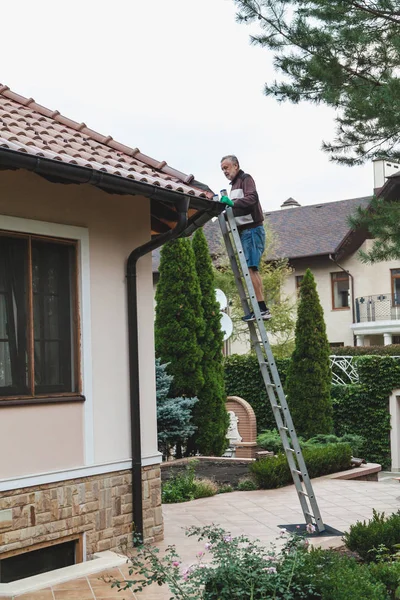 Homem Adulto Fica Uma Escada Metal Repara Telhado Azulejos Contra — Fotografia de Stock