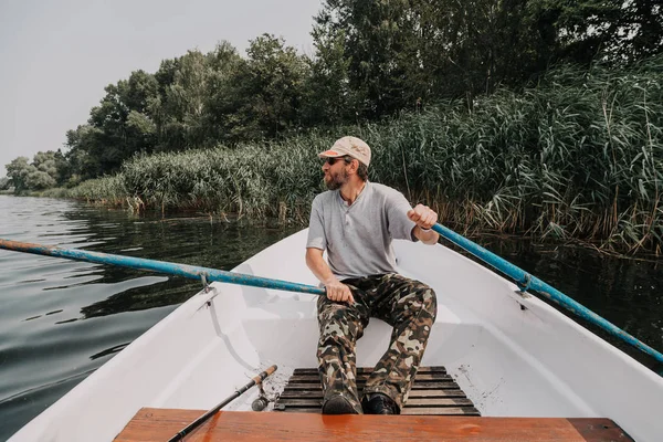 Man Beard Glasses Camouflaged Trousers Controls Rowing Boat Middle River — Stock Photo, Image