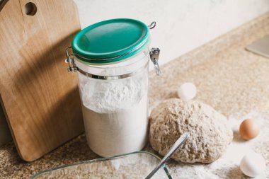 Yemek pasta. Hamur, un, yumurta ve bir cam kavanoza bir parça vardır bir granit tezgah