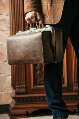 Şık bir ceketi olan beyefendinin elinde bir vintage ve bir ba...