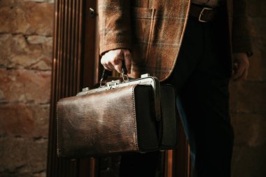 Şık bir ceketi olan beyefendinin elinde bir vintage ve bir ba...