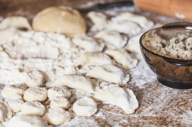 Mermer masa üstü çiğ köfte ve bir parça hamur beyaz un içinde yalan. Yakınlarda bir rüyamı ile bir cam olduğunu