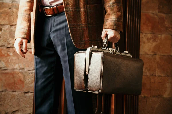 Şık bir ceketi olan beyefendinin elinde bir vintage ve bir ba...