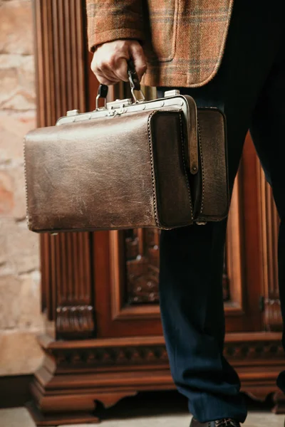 Şık bir ceketi olan beyefendinin elinde bir vintage ve bir ba...