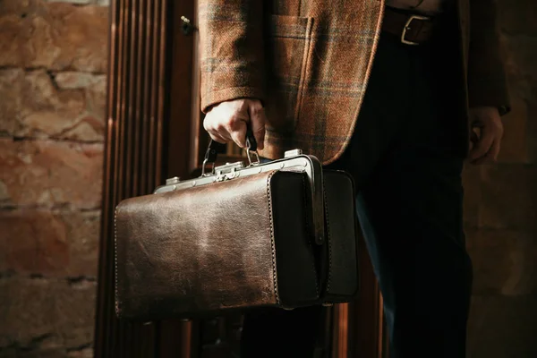 Şık bir ceketi olan beyefendinin elinde bir vintage ve bir ba...