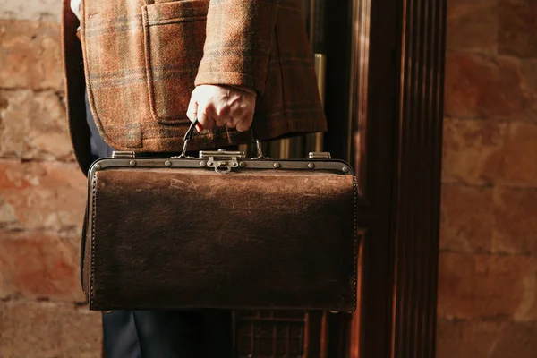 Şık bir ceketi olan beyefendinin elinde bir vintage ve bir ba...