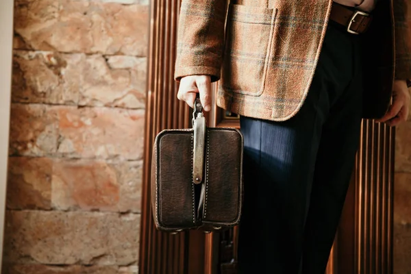 Şık bir ceketi olan beyefendinin elinde bir vintage ve bir ba...