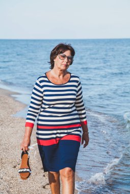 Çok yaşlı kadın güneş gözlüğü tatilde deniz tarafından 