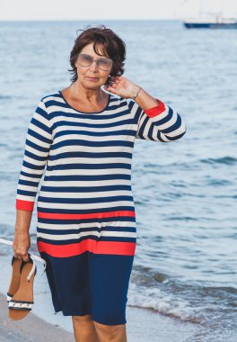 Güneş gözlüğü tatilde deniz gemi arka plan üzerinde oldukça yaşlı kadın