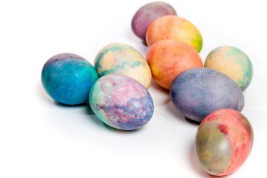 Paskalya tatiline özen göster. Farklı renklerde boyanmış birkaç tavuk yumurtası beyaz bir sırt grubunda.