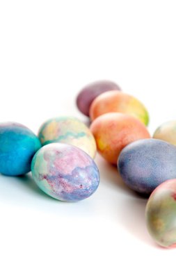 Paskalya tatiline özen göster. Farklı renklerde boyanmış birkaç tavuk yumurtası beyaz bir sırt grubunda.