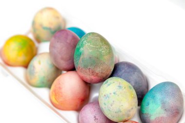 Paskalya tatiline özen göster. Farklı renklerde boyanmış tavuk yumurtaları, hücreli plastik bir kapta bulunur.
