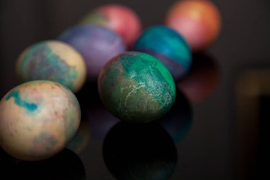 Öznitelik Paskalya tatili. Başlangıçta farklı renklerde boyanmış birkaç tavuk yumurtası üzerinde siyah bir adam vardır