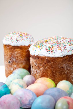 Aslında tavuk yumurtası beyaz bir adam üzerinde iki Paskalya kek ve birkaç çok renkli boyalı