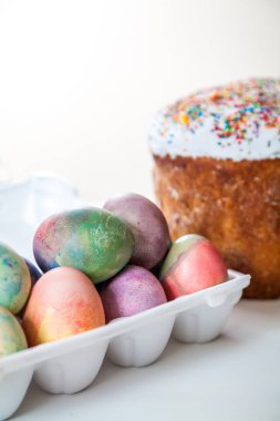 Paskalya kek ve plastik bir tepsi üzerinde beyaz bir adam birkaç çok renkli, başlangıçta boyalı tavuk yumurta