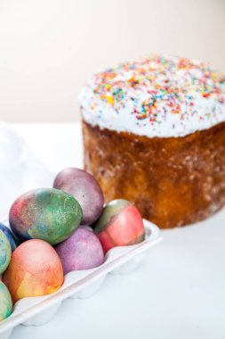 Paskalya kek ve plastik bir tepsi üzerinde beyaz bir adam birkaç çok renkli, başlangıçta boyalı tavuk yumurta