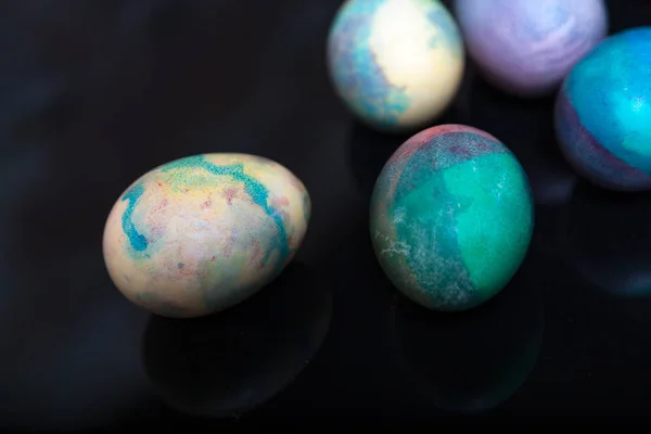 Stock image Attribute Easter holiday. Several chicken eggs originally painted in different colors are on a black backgroun