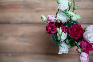 Bahar geldi. Bir buket kırmızı Eustoma üzerinde ahşap kurulların arka plan bulanık. Abov görüntülemek