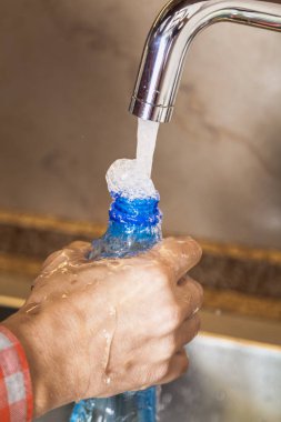 El tutma şişe musluk altında