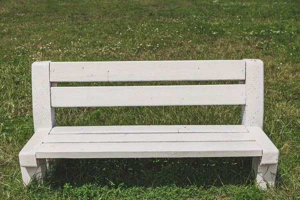 Vita bänken står på grönt gräs — Stockfoto