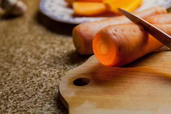 Carota rossa matura e coltello sdraiato su tavola di legno — Foto Stock