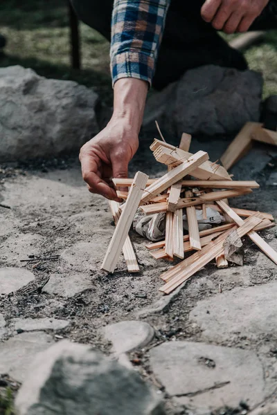 hand kindles fire between folded chips