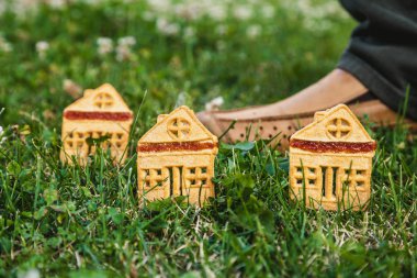 Çerezler küçük ev şeklinde yeşil çimenlerin üzerinde durmak