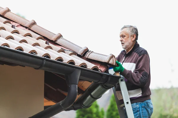 Man repairs tiled roof of  house close up — Stock Photo, Image